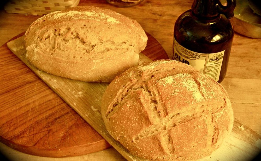 my deck oven mid-bake with the steam just fired — loaves springing on the stone (placeholder)