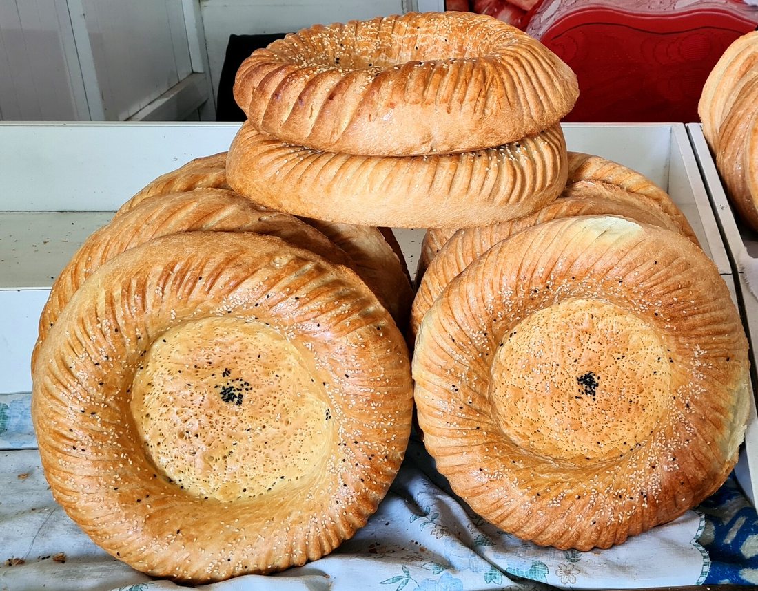 Stacked Uzbek non with thick scalloped rims and flat, stamped centres sprinkled with seeds