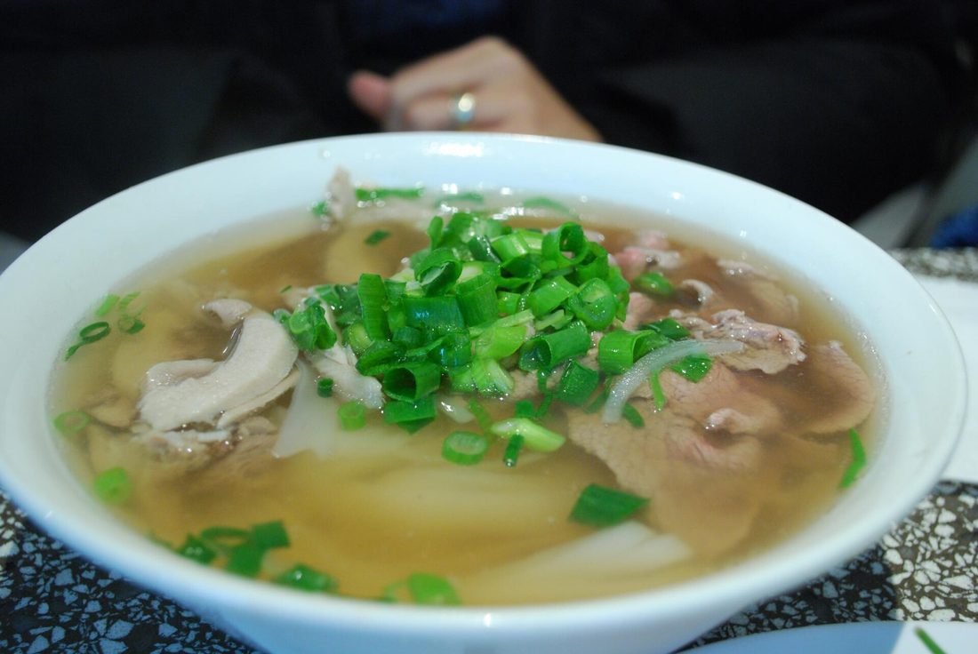 A bowl of phở with beef and herbs