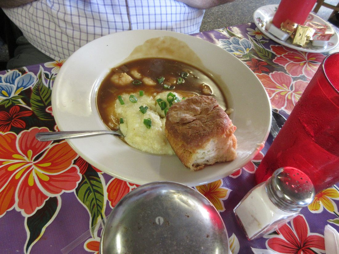 Shrimp and grits, the grits visible under the shrimp