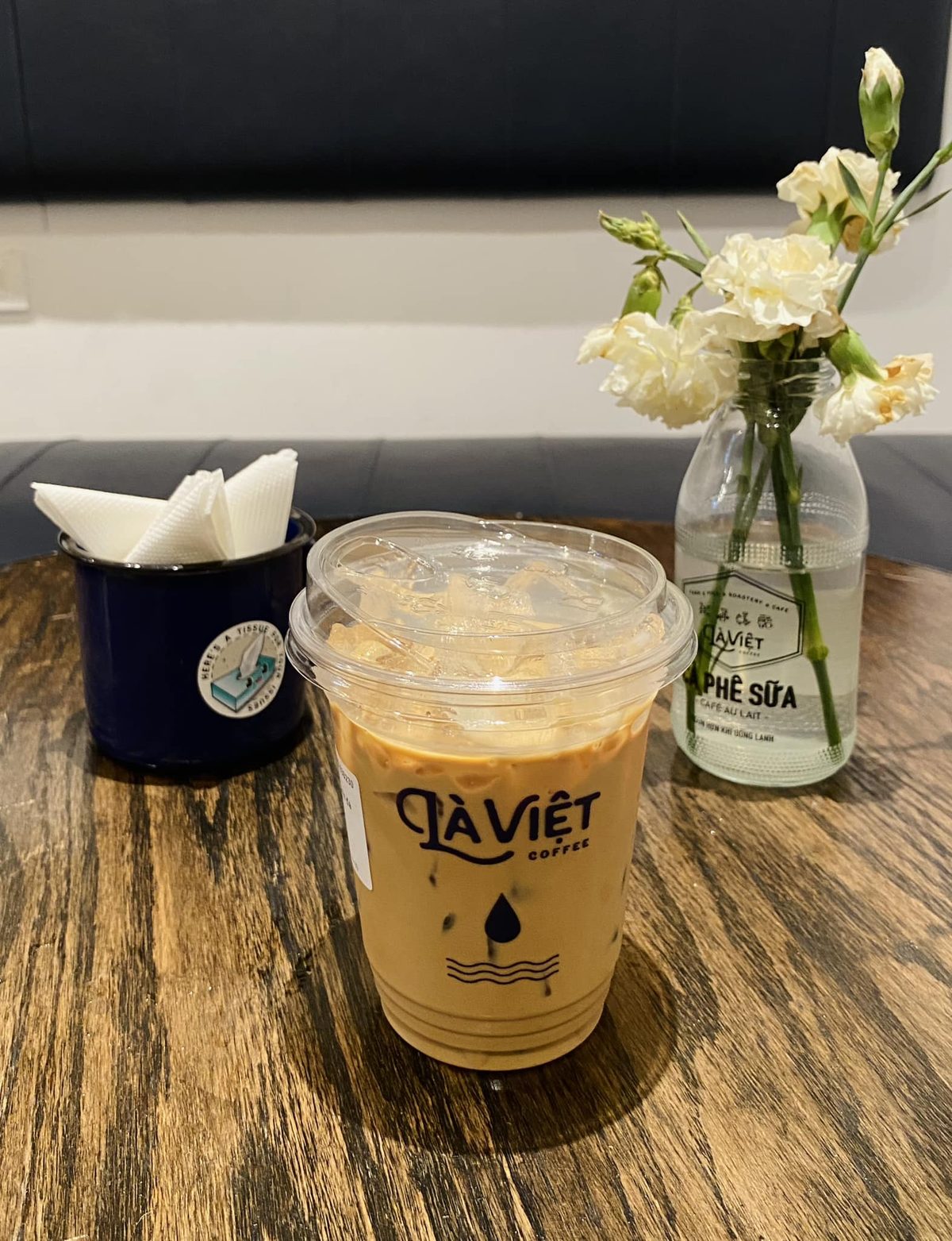 Cà phê sữa đá as it's actually served — already stirred through and poured over ice, the condensed milk long since mixed in. The phin that made it is back at the counter