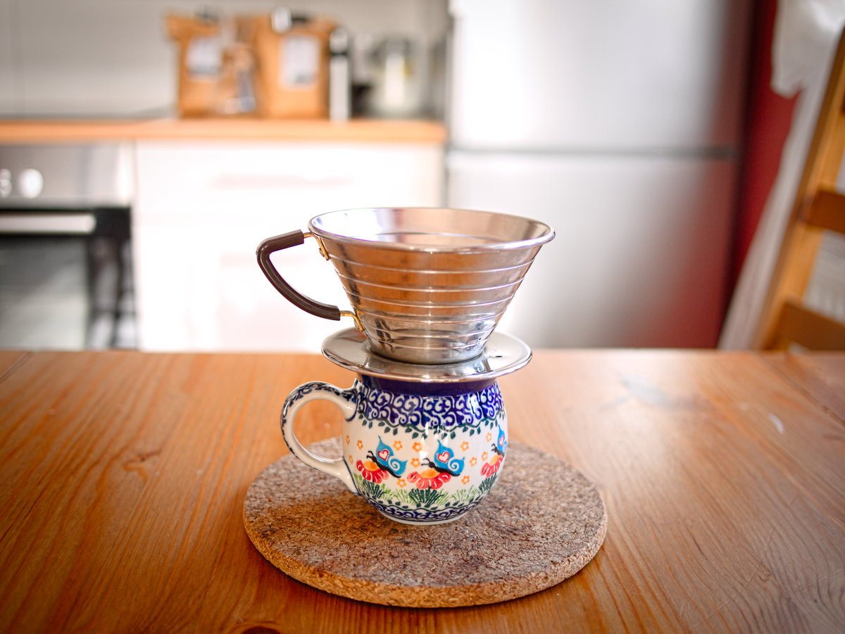A steel Kalita Wave sitting on a mug — note the flat base and straight sides, the opposite of the V60's cone