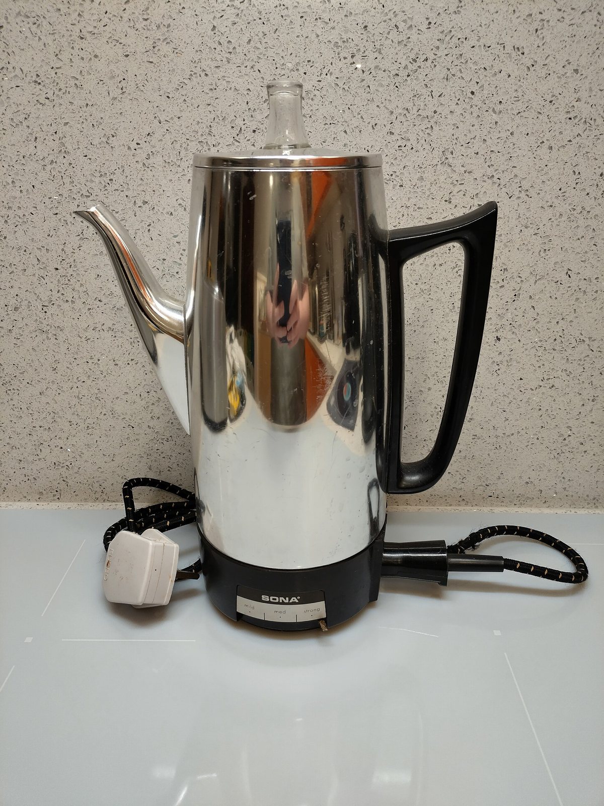 An electric percolator — the glass knob on the lid is where you watch the perk, and the tube up the middle is the whole mechanism