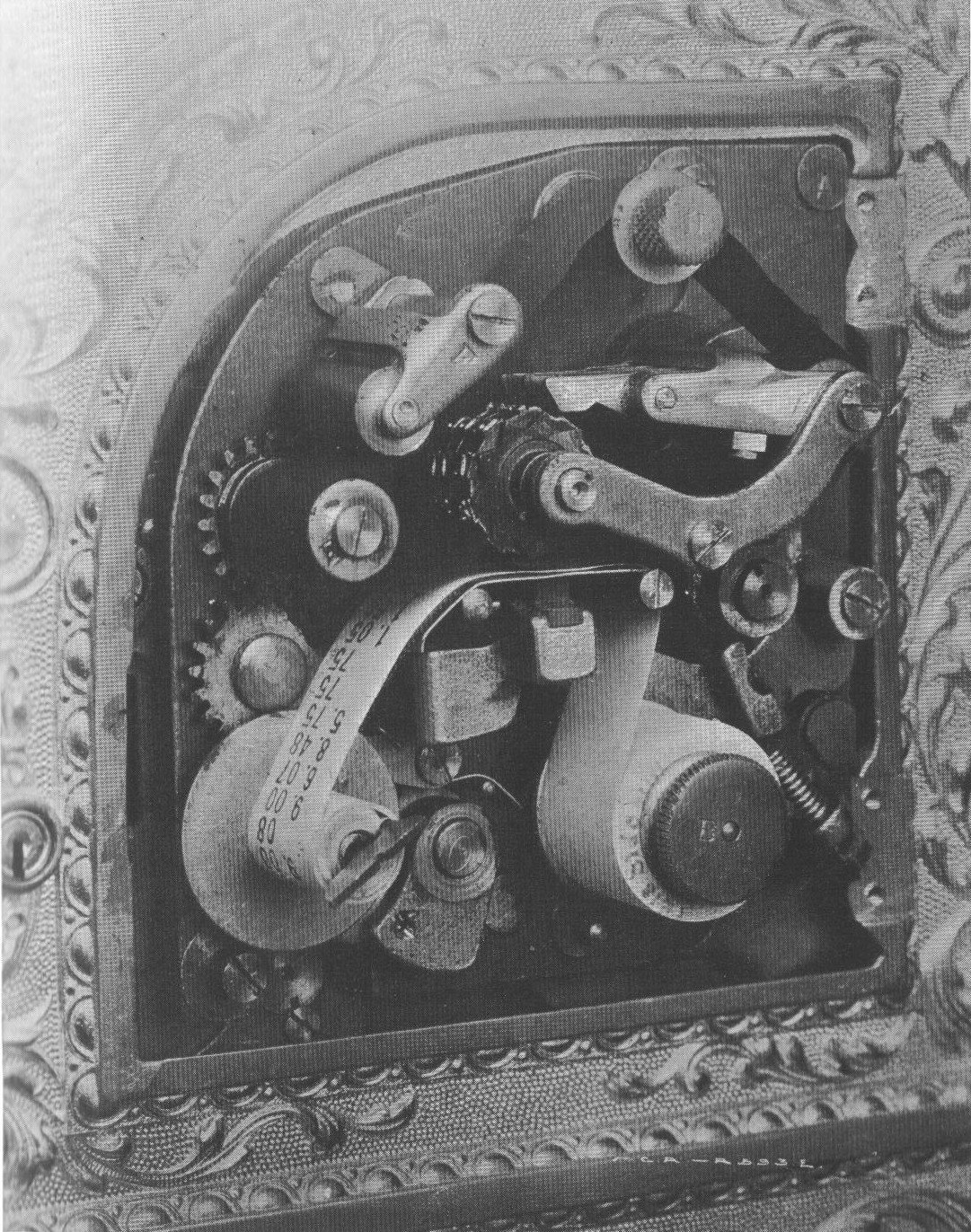 A black-and-white engraving of the inside of a mechanical cash register, showing its gears, levers and counting wheels