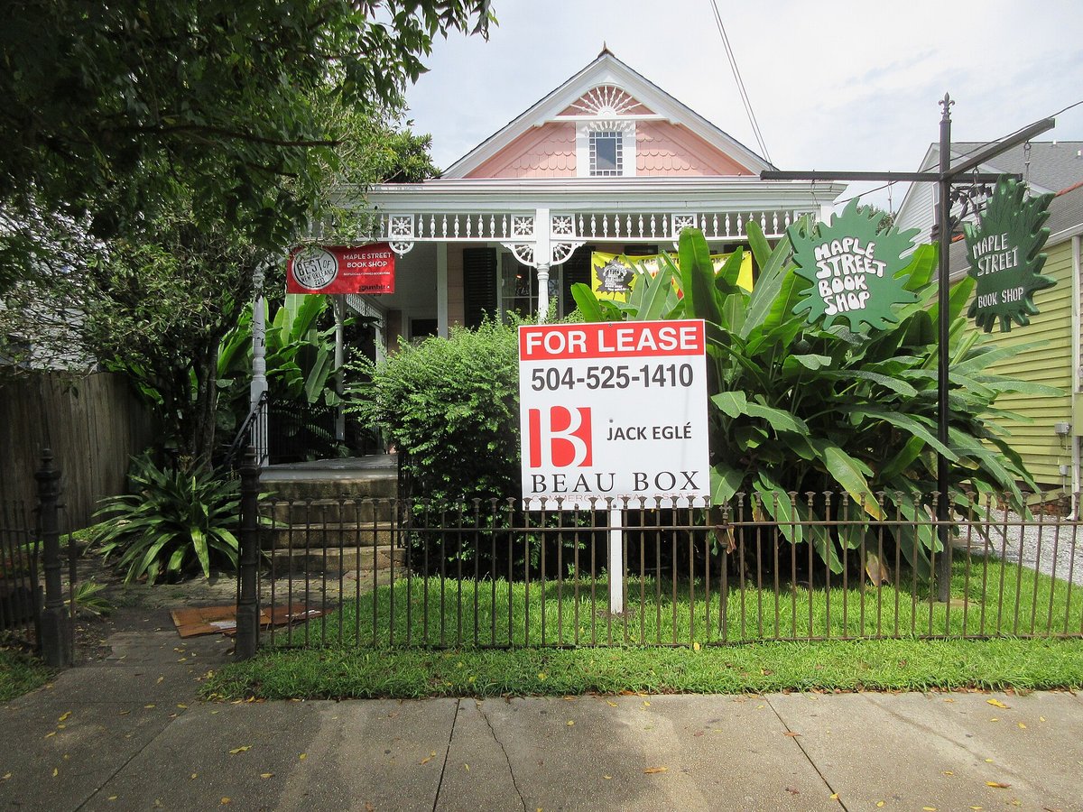 A Victorian house behind an iron fence with a For Lease sign on the lawn