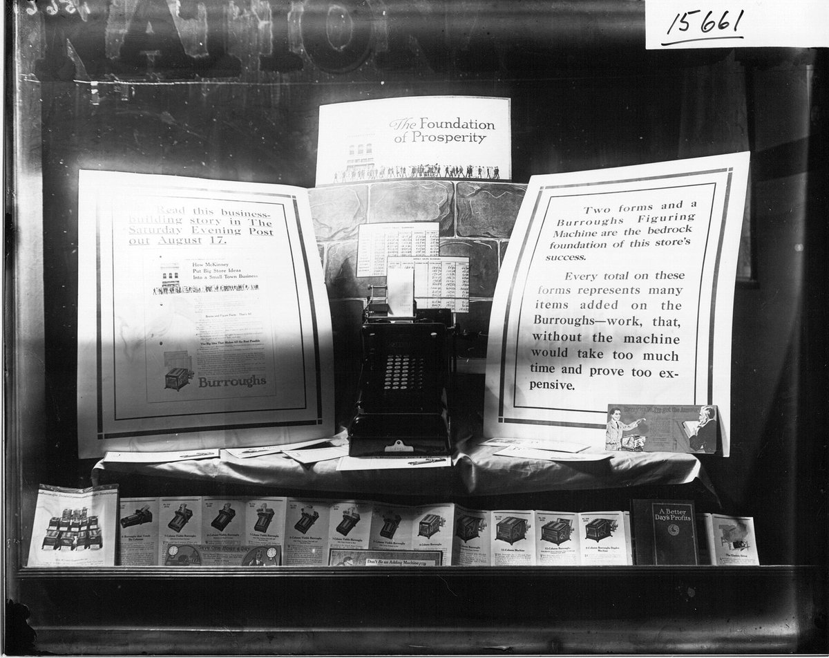 A 1916 bank window display of a Burroughs adding machine with placards reading The Foundation of Prosperity