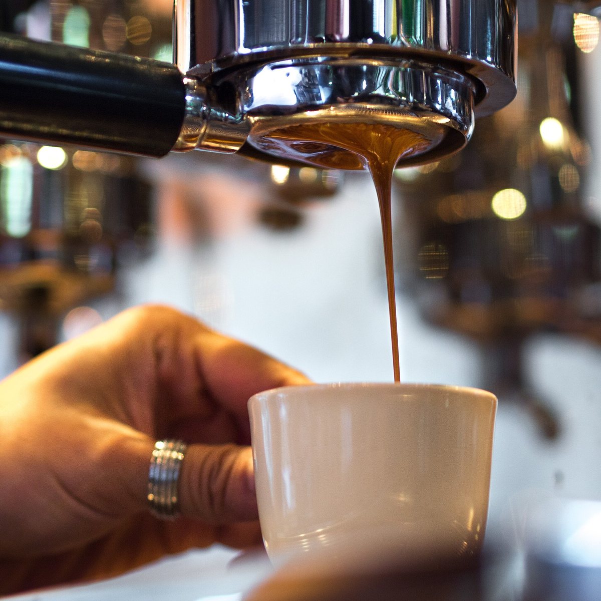 The same view in a café — the shot converging cleanly off the basket into the cup