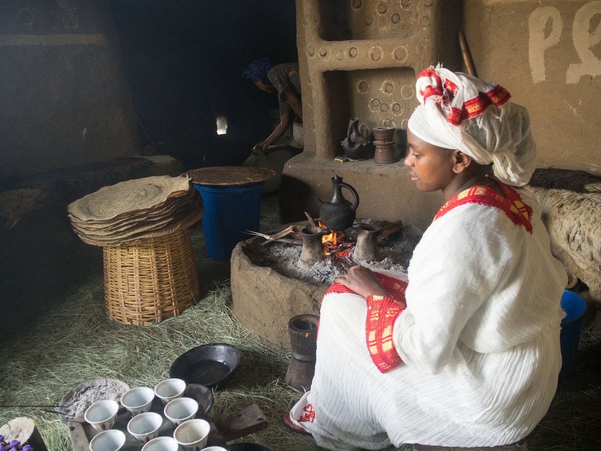 The Ethiopian coffee ceremony — green beans roasting in a pan over coals, the cups already set out, because the roasting is part of the hosting