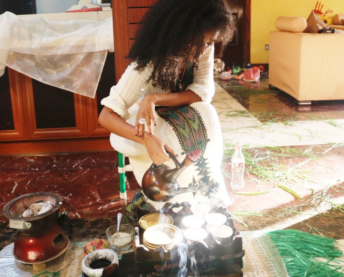 Pouring from the clay jebena. The long neck strains the grounds, and the pour happens from a height on purpose