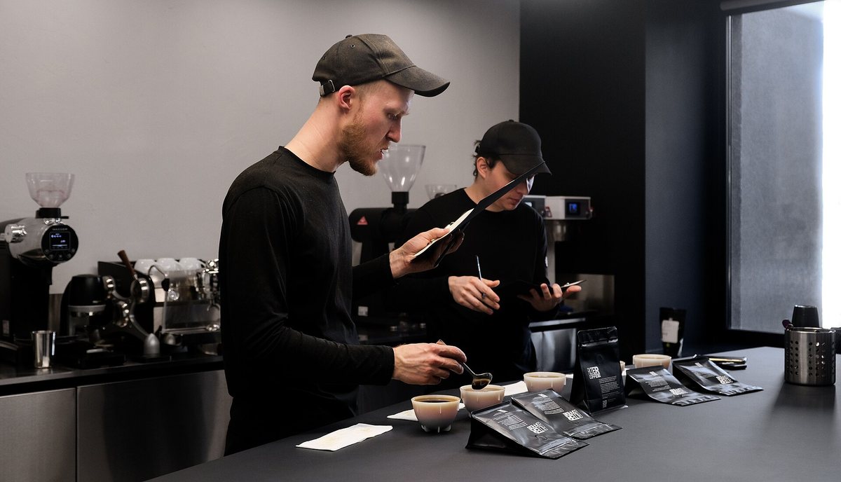 Cupping in a roastery lab. Every batch a good roaster sells was tasted this way first — which is the actual difference between roasting and burning