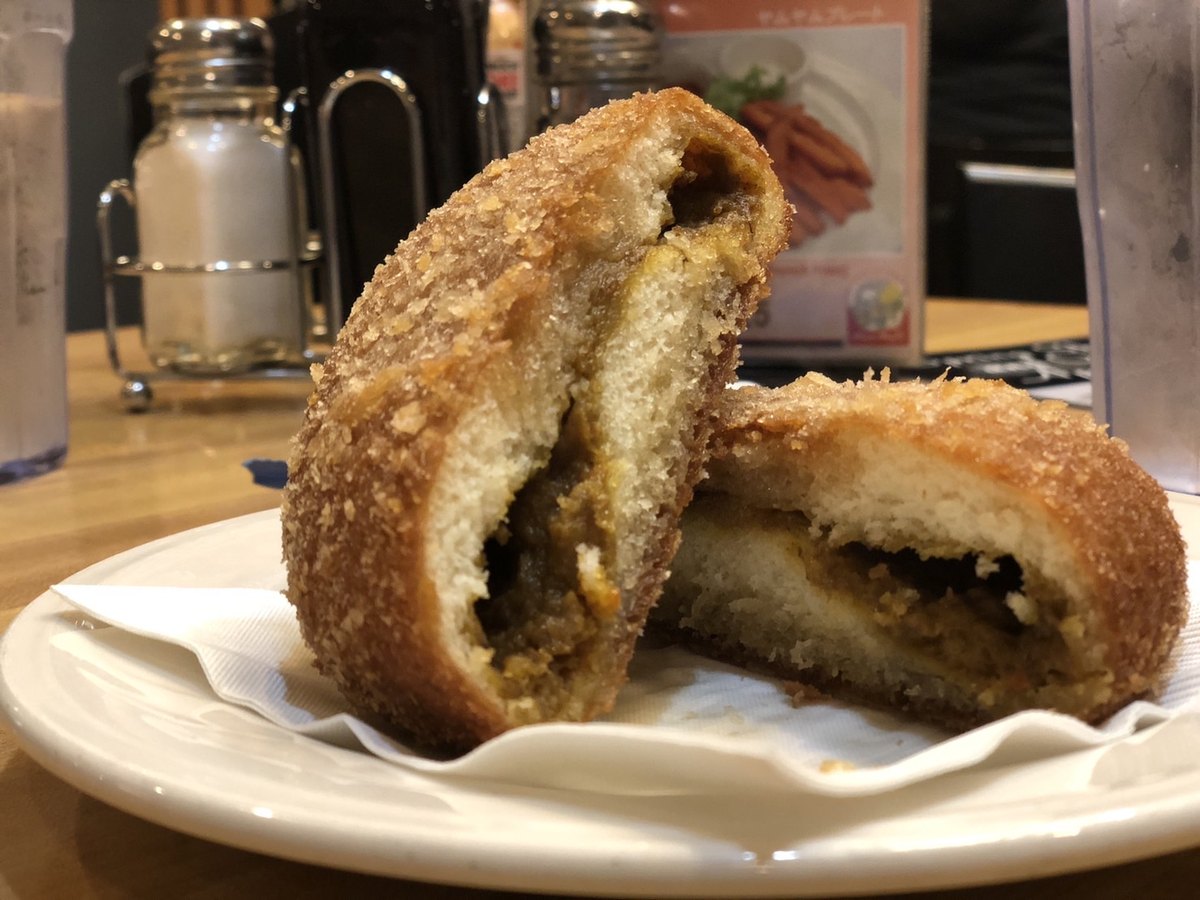 Karē pan cut open — curry baked inside a crumbed, fried bread roll