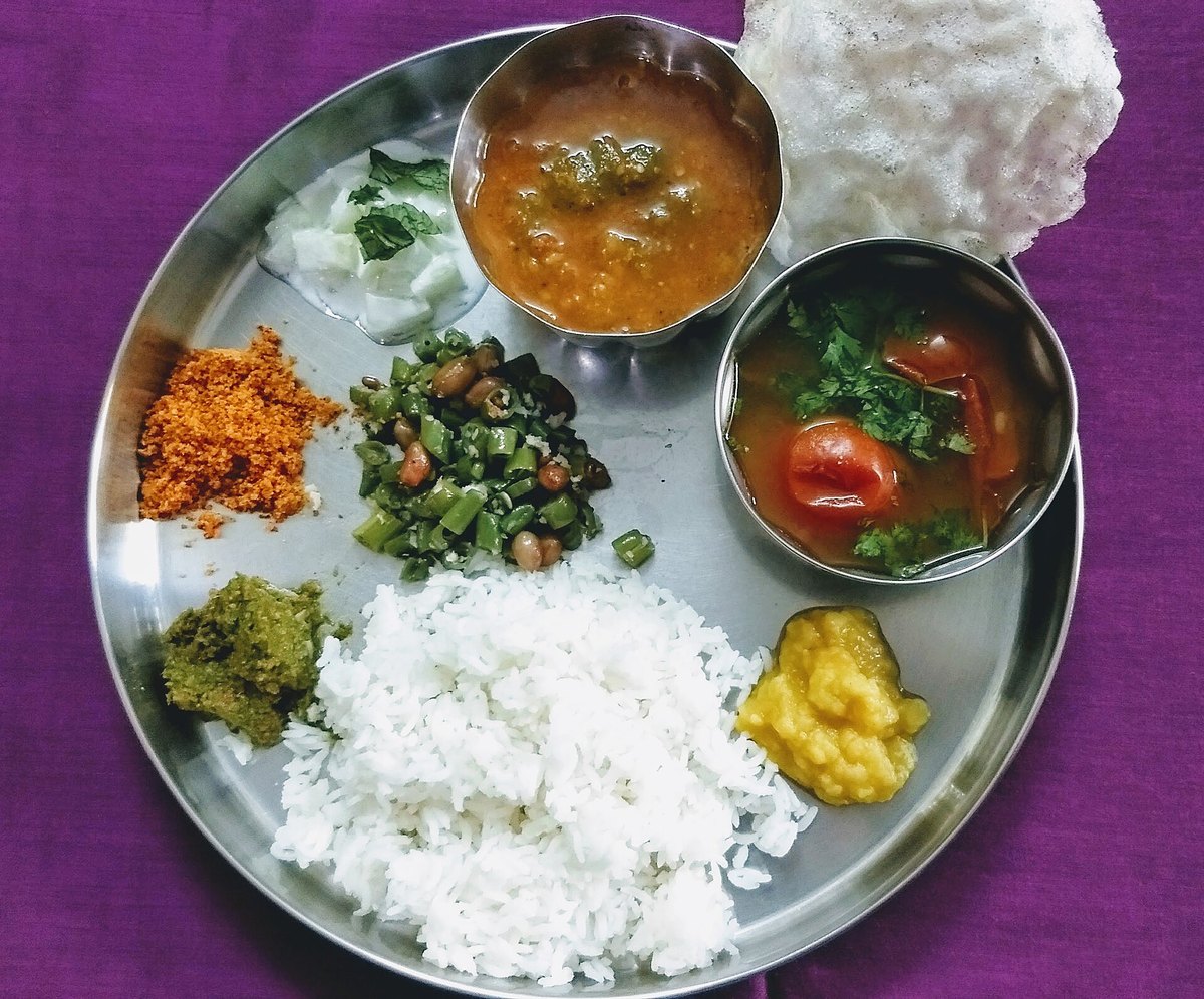 A South Indian home-cooked meal on a steel plate — several separate preparations, rice at the centre, none of them a single thing called "curry"