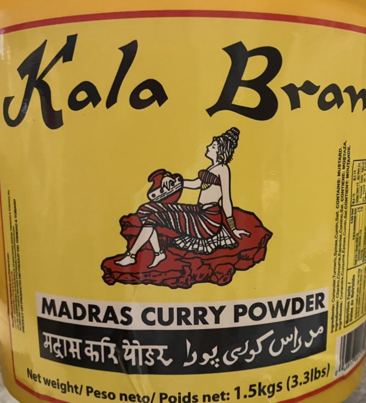 Tubs and cans of Thai curry paste on a shelf, showing the range of formats