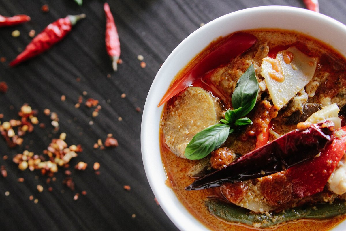 A red curry with chicken and Thai basil, the surface showing the broken coconut oil that marks a properly cooked one