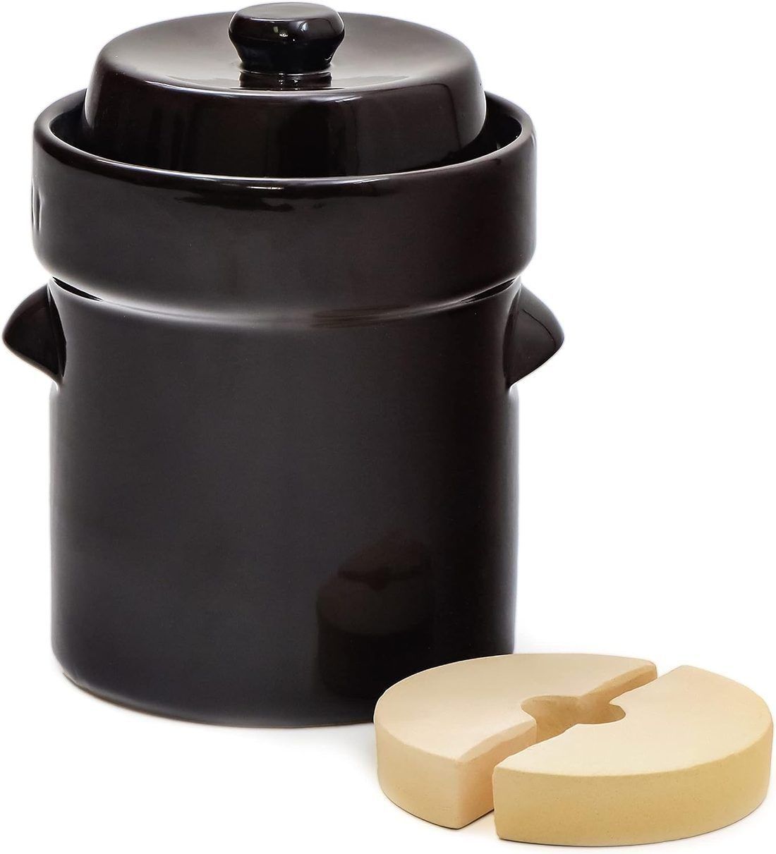 A glazed crock with its two-piece ceramic weight in front. The halves go in one at a time through the mouth and sit flat on the vegetables