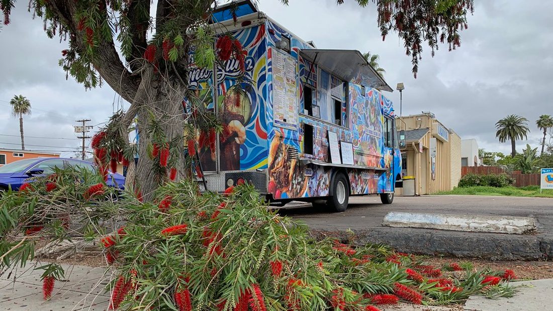 A Michigan food truck at a local event with a health-department permit posted in the service window