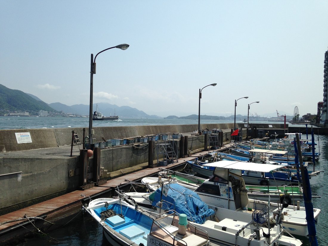 A working fishing port — small boats against a concrete quay. This is what I was actually stopping at: not a view, a place where people were doing something