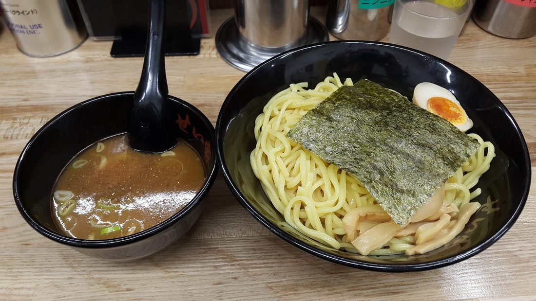 A bowl of ramen topped with a halved marinated egg