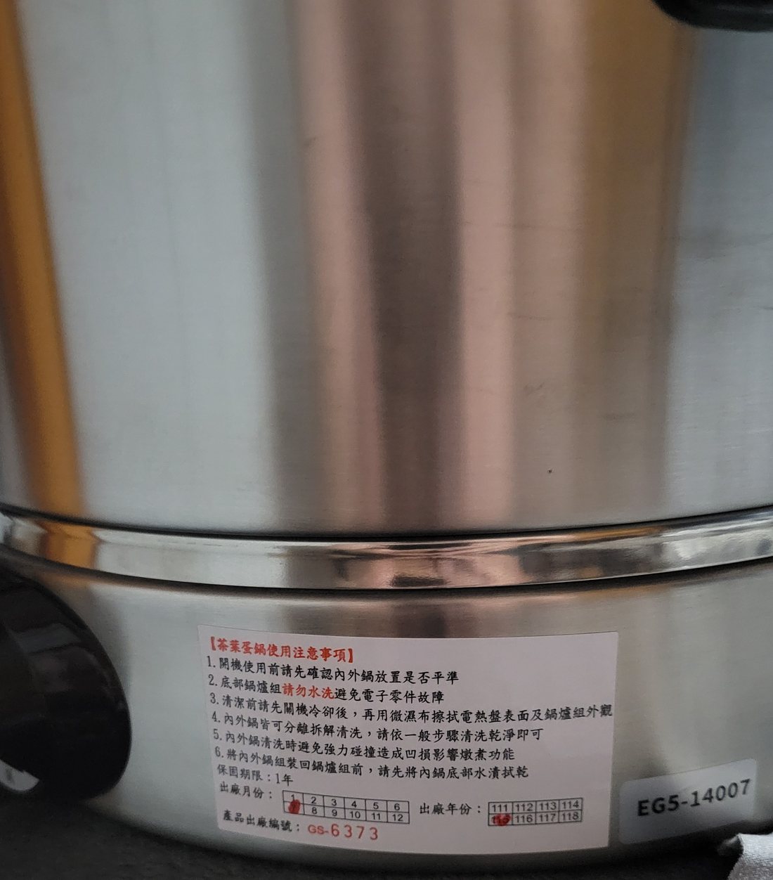 The Chinese-language precautions label on the pot body, with the manufacture date and serial number