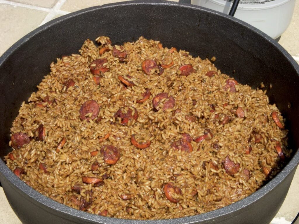 A cast-iron pot of jambalaya, rice flecked with sausage, shrimp, and the "holy trinity" of onion, celery, and bell pepper