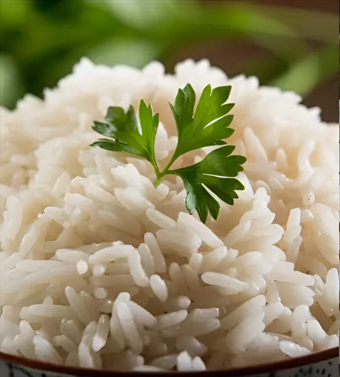 Two spoonfuls of cooked rice side by side, left a mound of fluffy separate long-grain basmati, right a glossy cohesive clump of short-grain sushi rice, showing the amylose difference