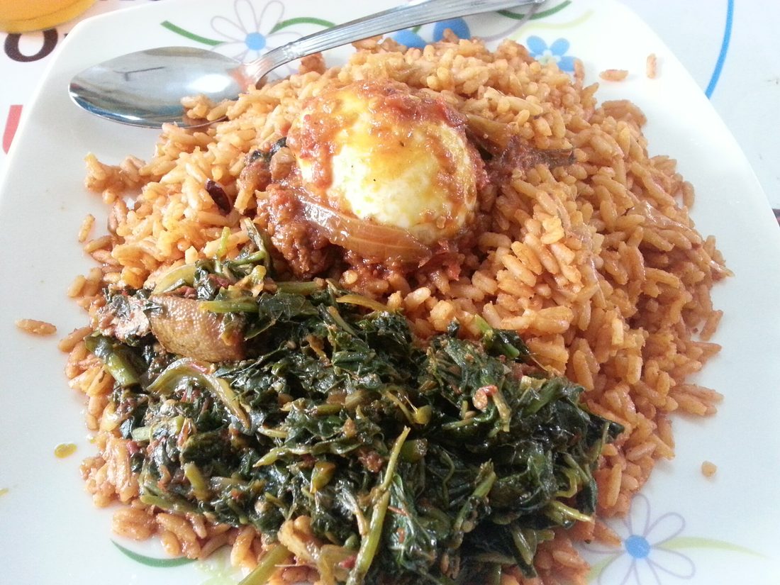 A pot of West African jollof rice — deep orange-red from tomato and pepper, cooked down until the bottom catches into a smoky crust, ready to serve