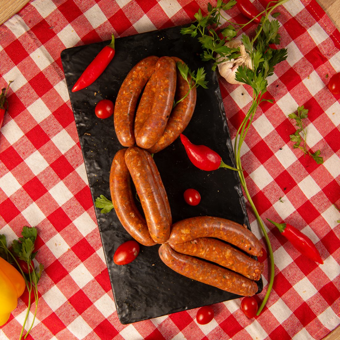 Merguez — the spicy lamb sausage of the Maghreb, red with harissa: a pure product of “we herd sheep and can't eat pork.”