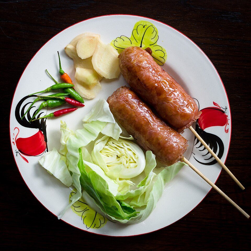 Sai krok Isan — the small, round, sour-fermented Thai pork-and-rice sausage, grilled and eaten with raw cabbage, chile and ginger.