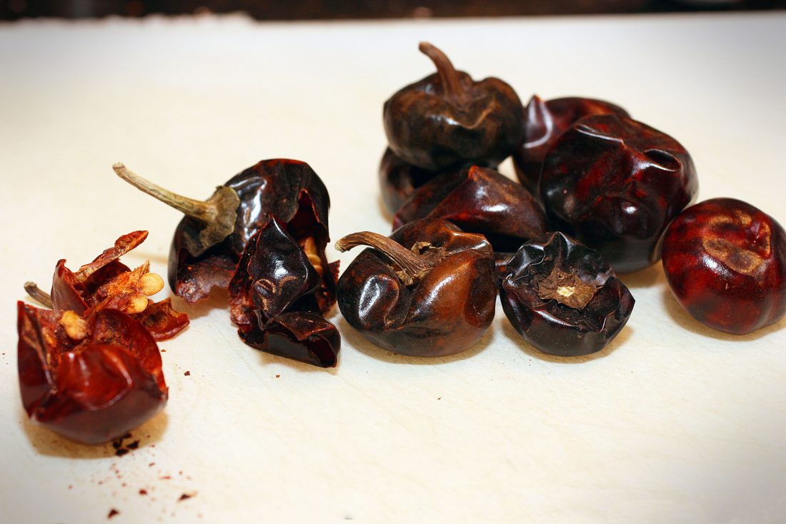 Dried chiles — the base of a real Mexican chorizo, toasted and rehydrated into a paste that carries both the heat and the deep red color, a completely different route from Spanish chorizo’s smoked pimentón.