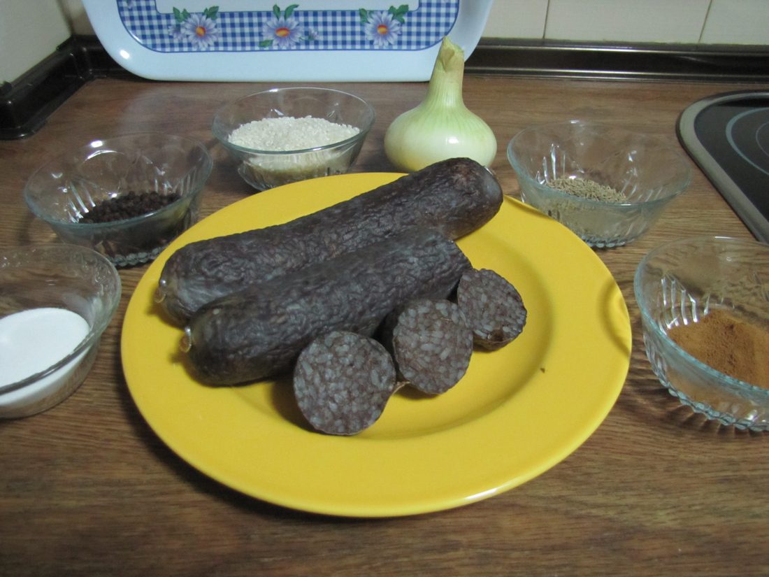 A sliced morcilla de Burgos: you can see the rice suspended in the set. The blood has coagulated with heat around the grain — it did not bind on extracted myosin the way a meat sausage does.
