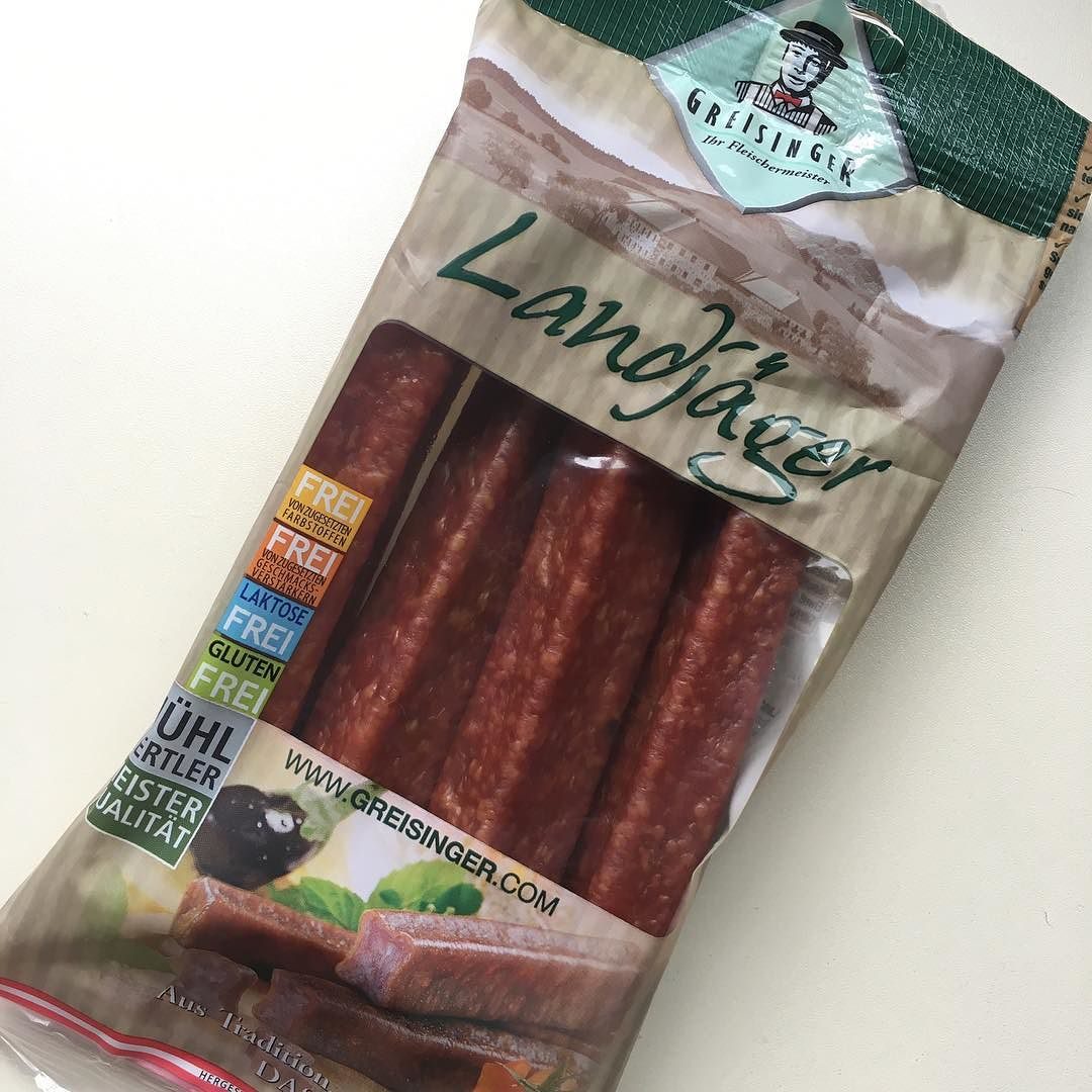 A retail vacuum pack of "Landjäger" from a store shelf — legally identical in name to a hand-made Black Forest pair, because the word is generic and unprotected; the film tells you nothing about whether what's inside was ever fermented or dried.