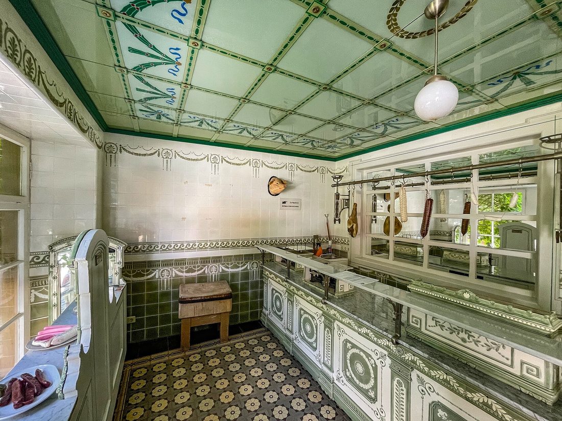 A traditional neighborhood butcher shop — the kind of tiled, stocked, counter-staffed place that has been vanishing for a century, where someone cut your meat to order.