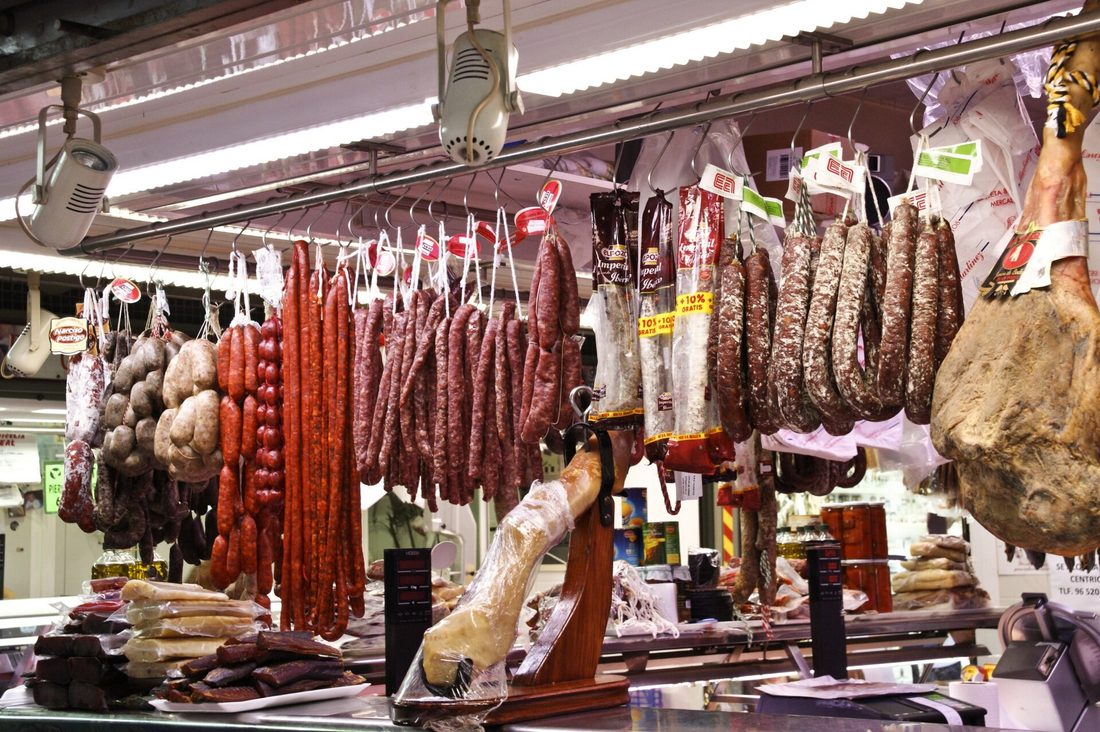 What real variety looks like — dozens of genuinely different cured sausages hanging in one shop, the opposite of a wall of snack sticks that all taste the same.