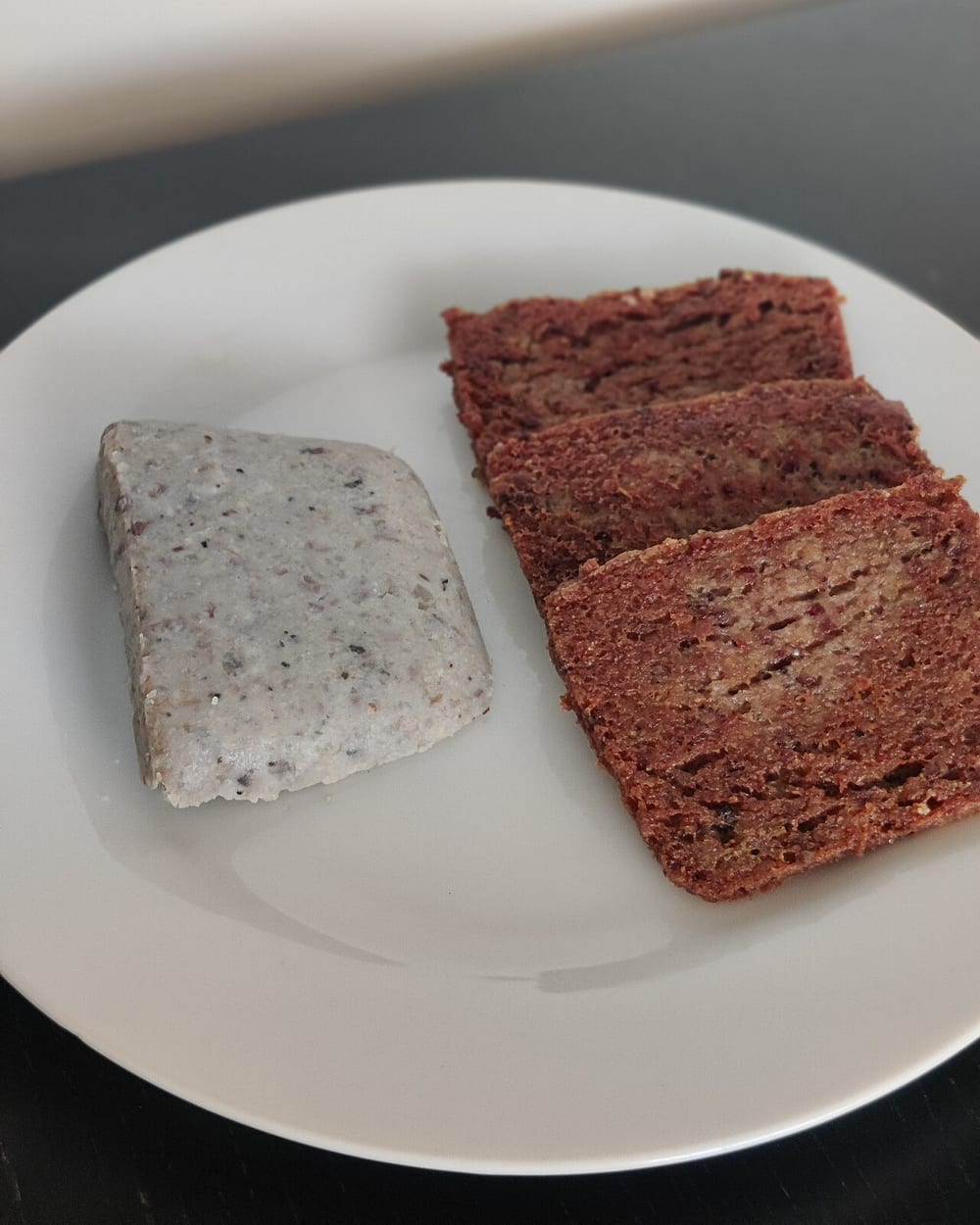A set loaf-pan pudding — scrapple here — turned out and sliced, holding its shape with no casing at any point