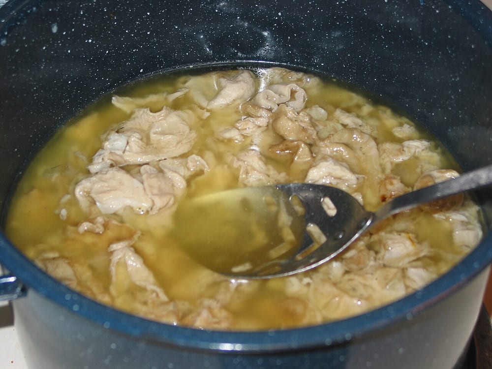 Cleaned pork chitterlings simmering in a deep pot — the American survival of the offal branch, still sold in every Southern grocery, and never once marketed as heritage anything