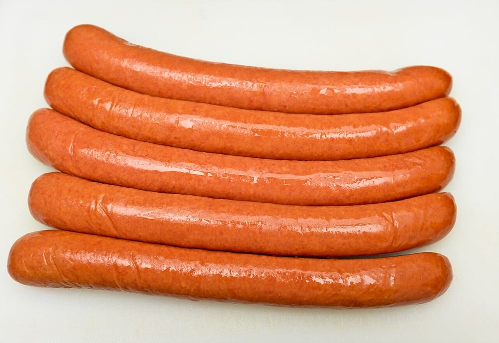 Natural-casing hot dogs — the emulsified sausage at its industrial endpoint, the interior perfectly homogeneous
