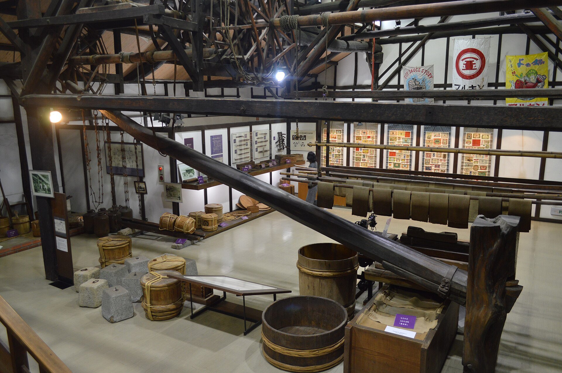 The interior of a soy sauce museum — wooden beams, old brewing equipment and rows of exhibits beneath a high roof