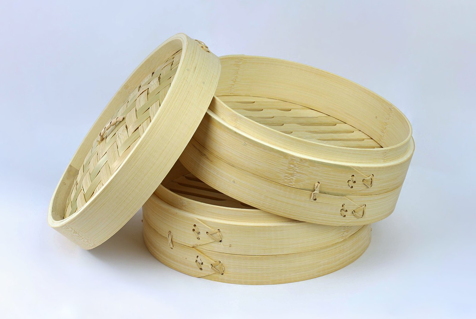 A stacked bamboo steamer with its woven lid