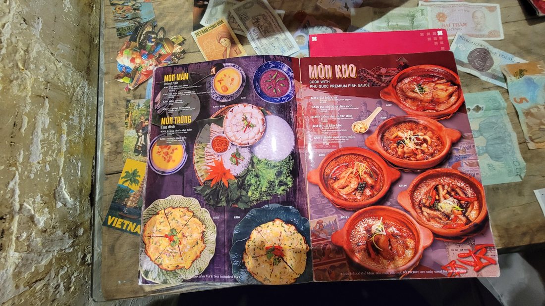 The MÓN MẮM / MÓN TRỨNG spread facing MÓN KHO — five clay pots of braises photographed from above, all of them in the same earthenware, on a table top decoupaged with banknotes