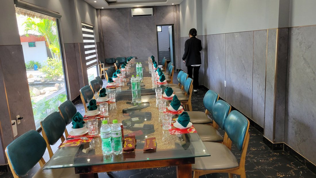 The room: a private dining room off the garden, one long glass table, set for a group