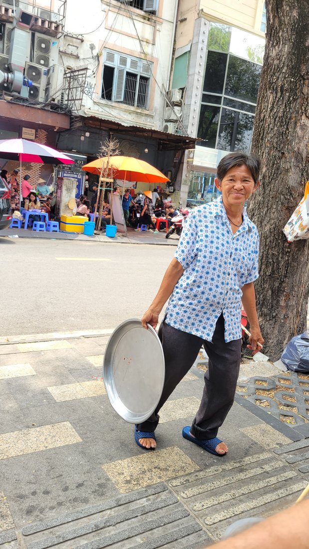 Carrying the pan. This is the frame I filed as "amazing new friend" — she is moving between the grill and the table here, not cooking in this particular shot