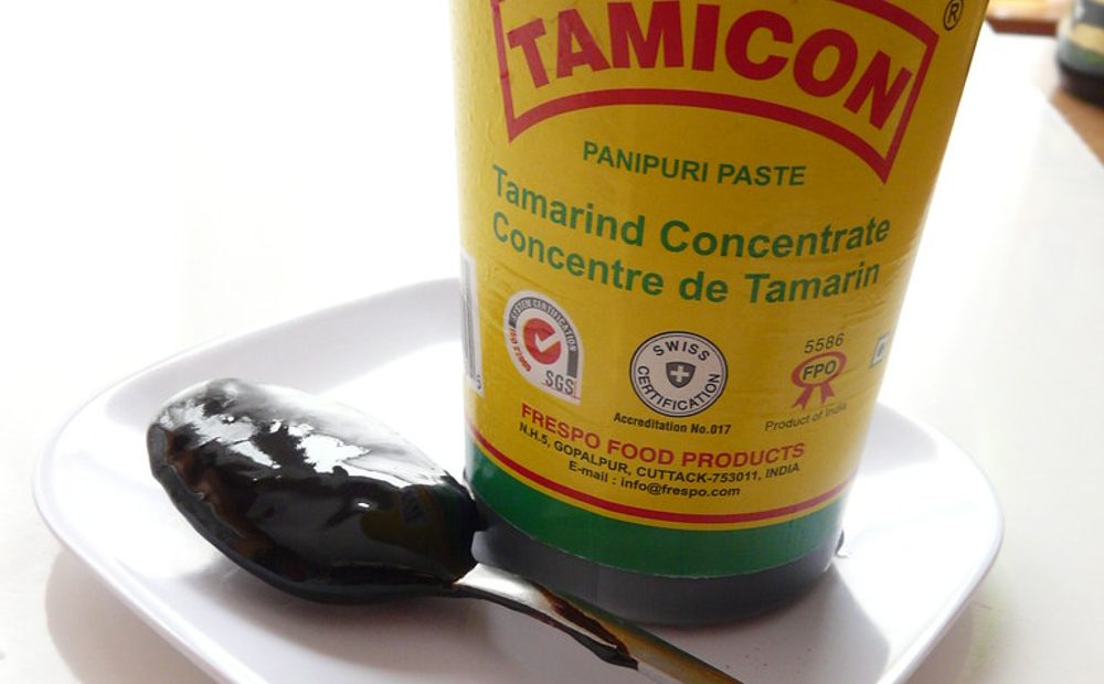 my jar of tamarind concentrate next to a block of seedless tamarind pulp, showing the sticky texture I work with when I make my own (placeholder)